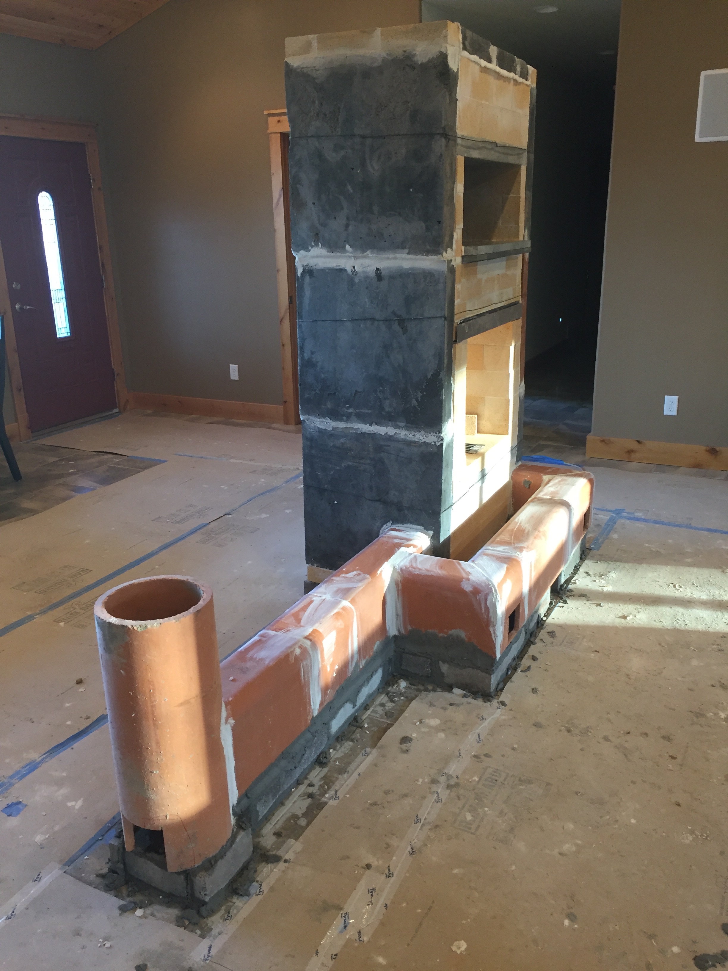 Finished Solid Rock Masonry Heater Core with front and side heated bench.