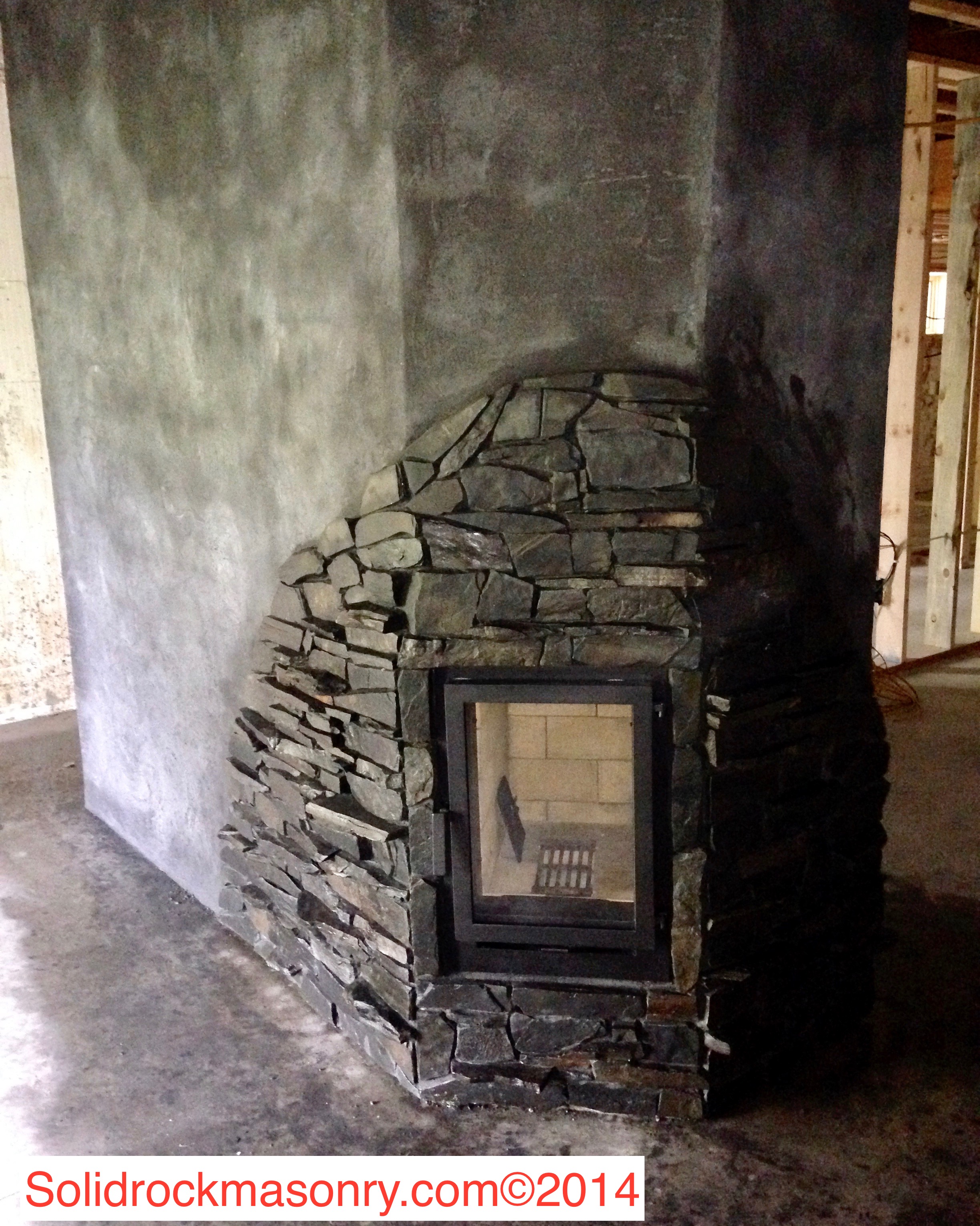 Sanborn SR-13 Masonry Heater corner unit. Finished with slate and stucco.